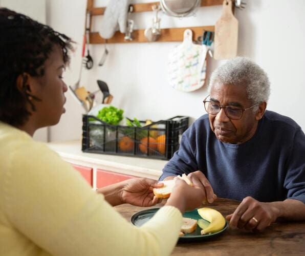 A woman and an older man sitting at a table.