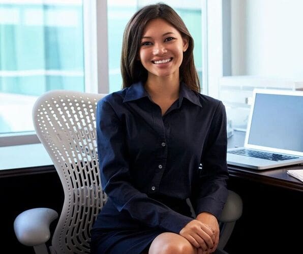 A woman sitting in front of a laptop computer.