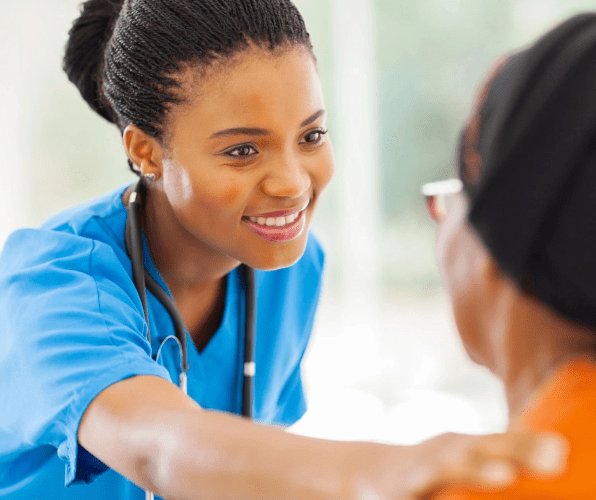 A woman in scrubs talking to someone else.