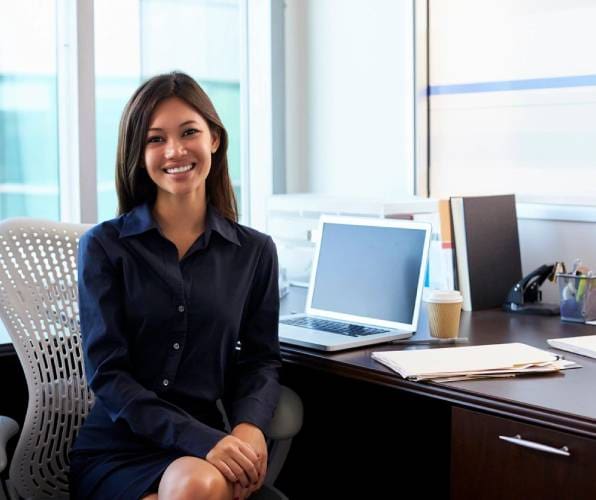 A woman sitting at her desk with a laptop.