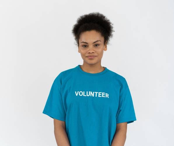 A woman wearing a blue shirt with the word " volunteer ".